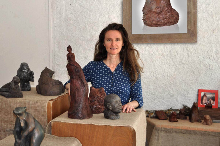 Sculptrice céramique Sylvie Brunet dessevre dans une salle d'exposition devant ses sculptures animaux