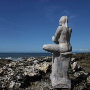 sculpture femme assise devant la mer